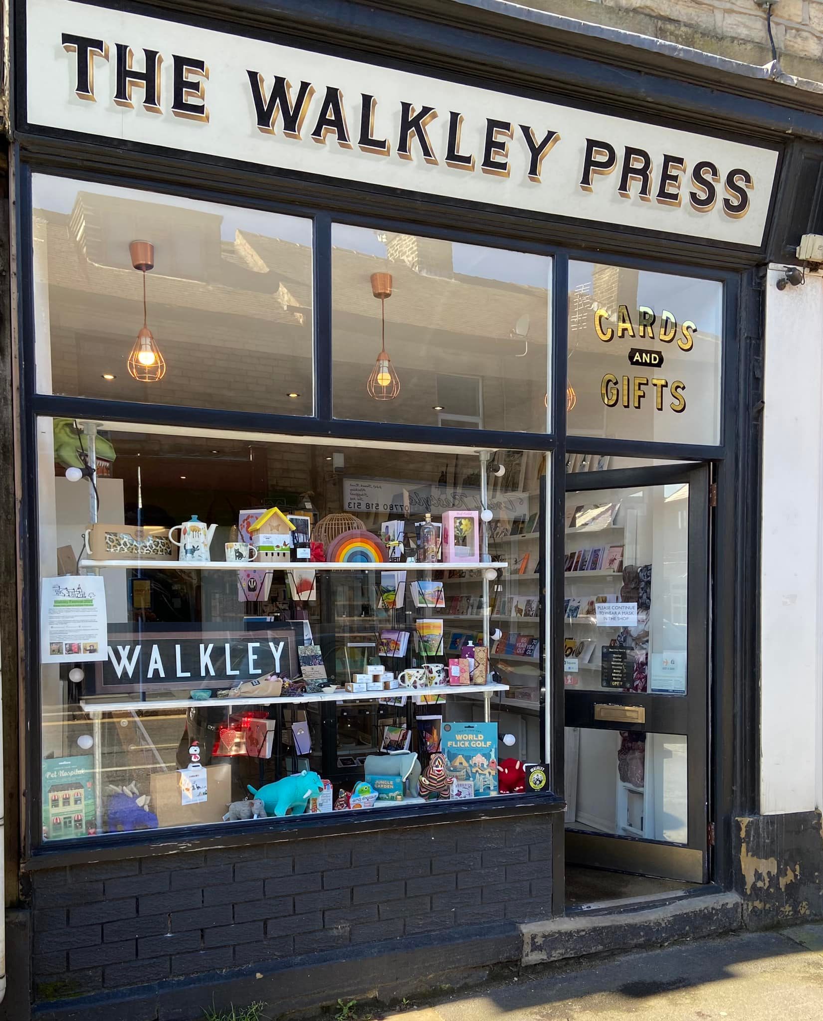 An exterior shot of The Walkley Press, who sell cards and gifts. There is a bright and cheerful window display.