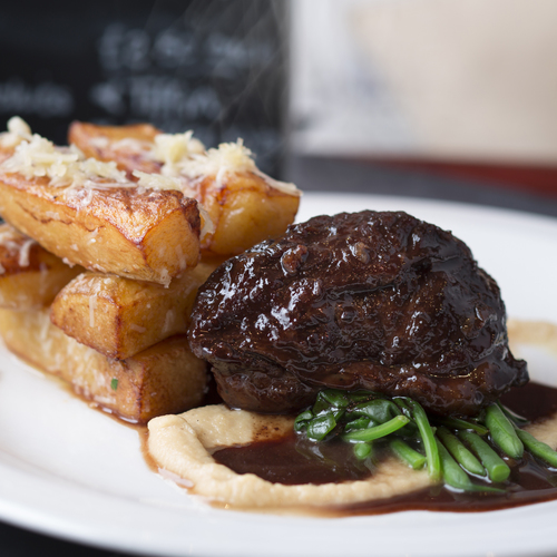 A cut of meet with chunky chips on a plate.