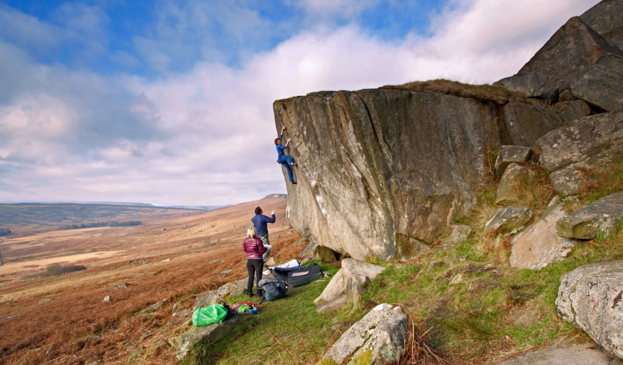 A group of people climbing a small rock face.