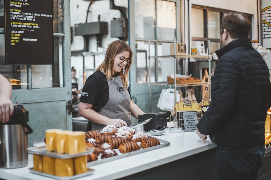 A customer at the counter, being served, at The Depot Bakery.