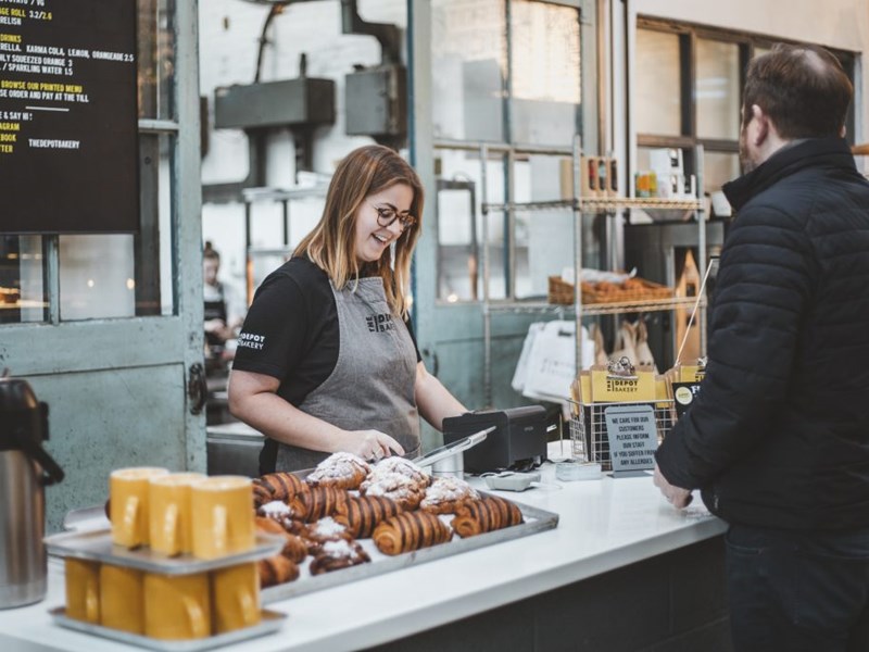 A customer at the counter, being served, at The Depot Bakery.