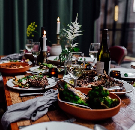 A table at The Mowbray full of food and wine.
