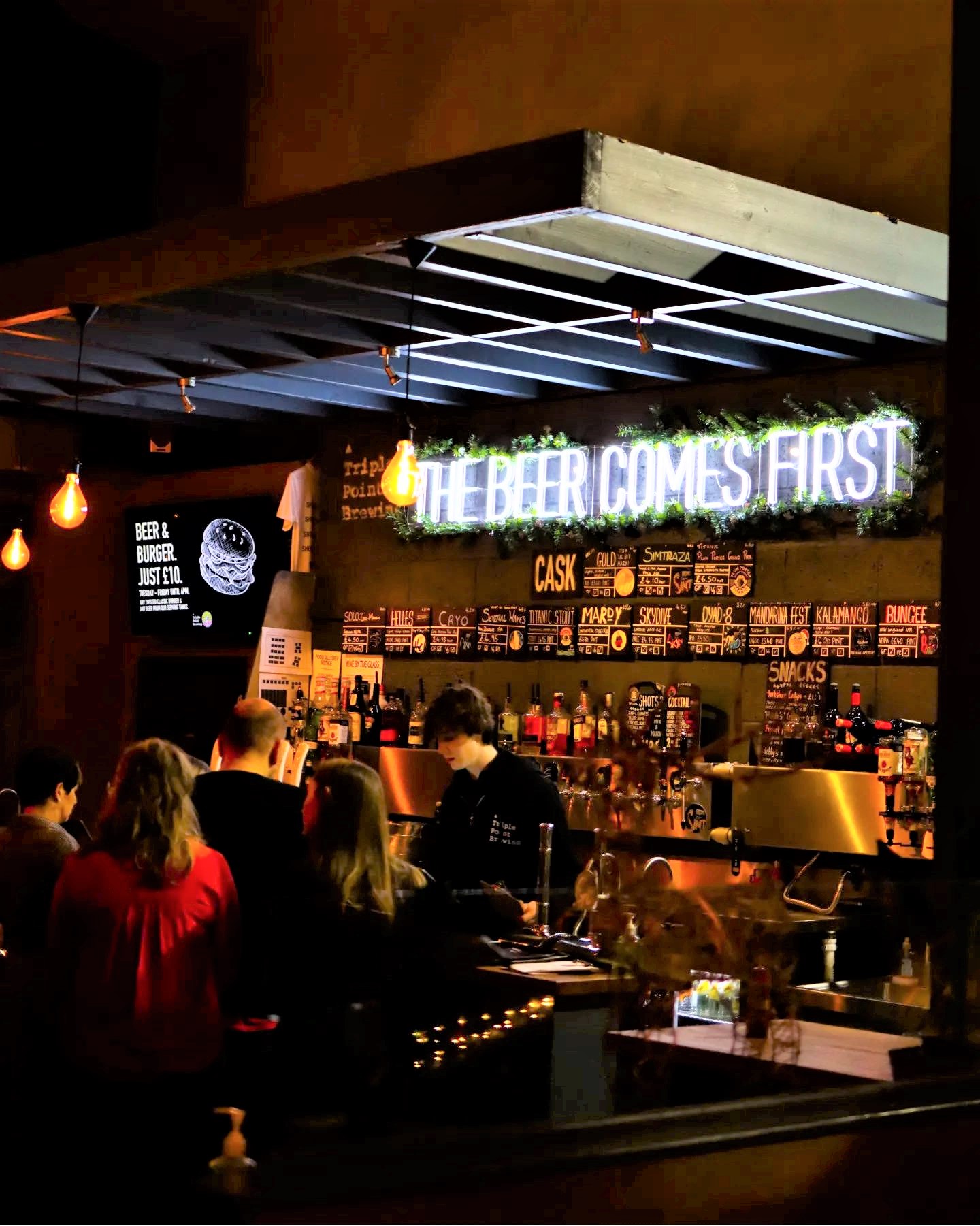 A crowd of people enjoying at night out at Triple Point Brewery.