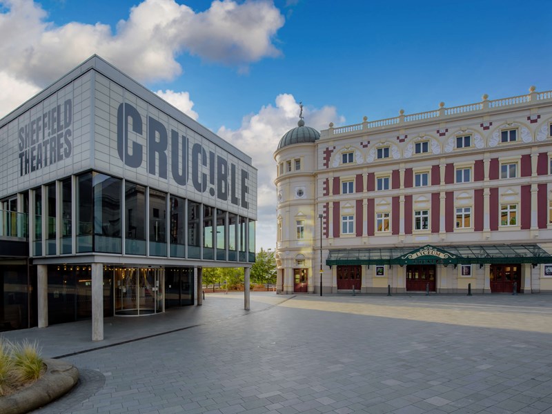 The exterior of teh Crucible Theatre, during the day, with the Lyceum Theatre in the background.