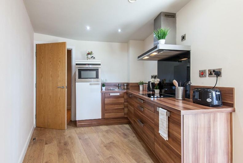 Compact kitchenette with essential appliances and storage cabinets.