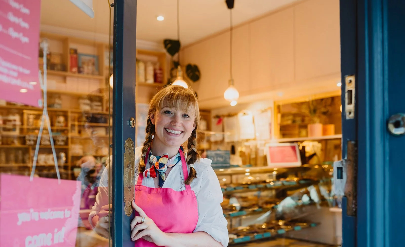 A smiling member of staff opening the door to Cocoa Wonderland.