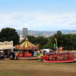 Food stalls and colourful fairground ride with people enjoying themselves at the Sheffield Fayre.