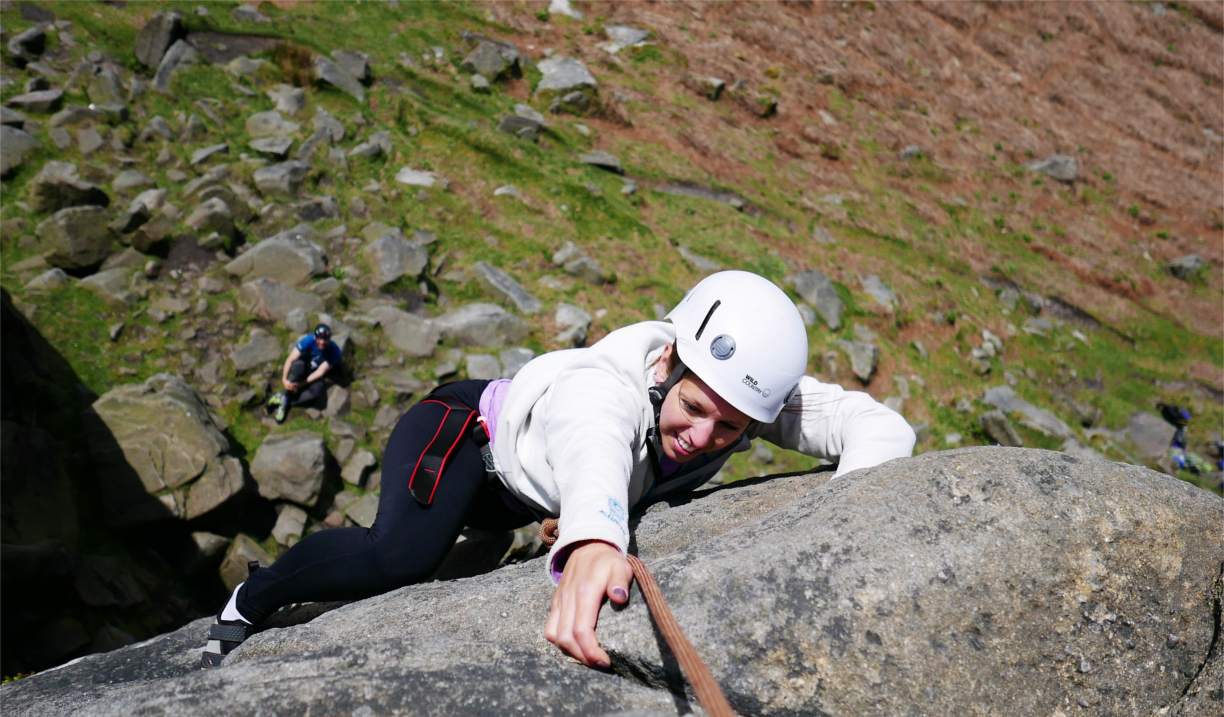 A woman climbing a rock face.