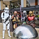 A group of people dressed in various storm trooper and Star Wars costumes pose in front of the steel ball sculptures in Sheffield City Centre