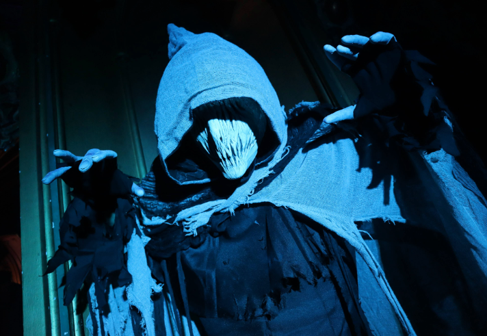 A spooky figure in a cloak and mask.