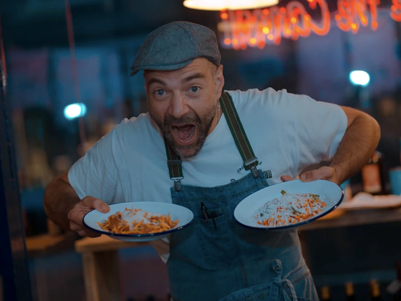 A chef holding two plates of food that are ready to go.