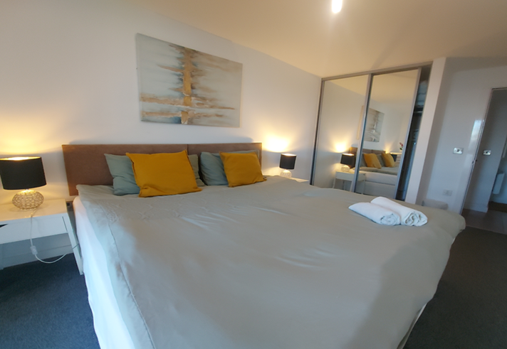 Double bed featuring soft furnishings and decorative cushions.