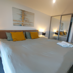 Double bed featuring soft furnishings and decorative cushions.