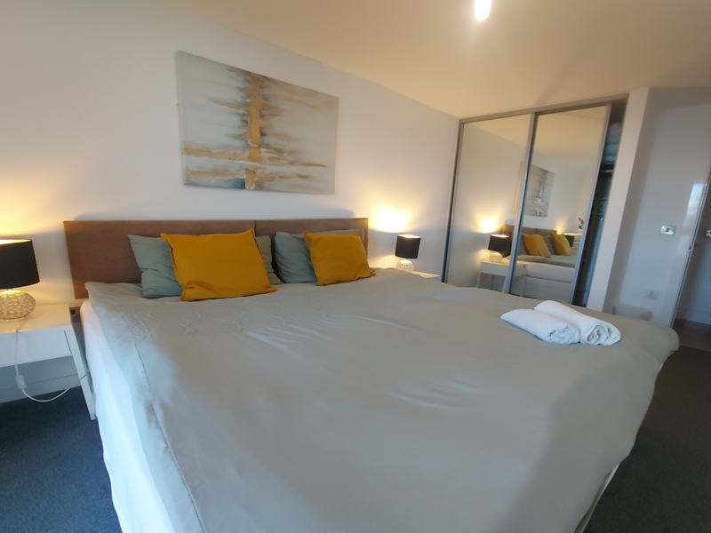 Double bed featuring soft furnishings and decorative cushions.