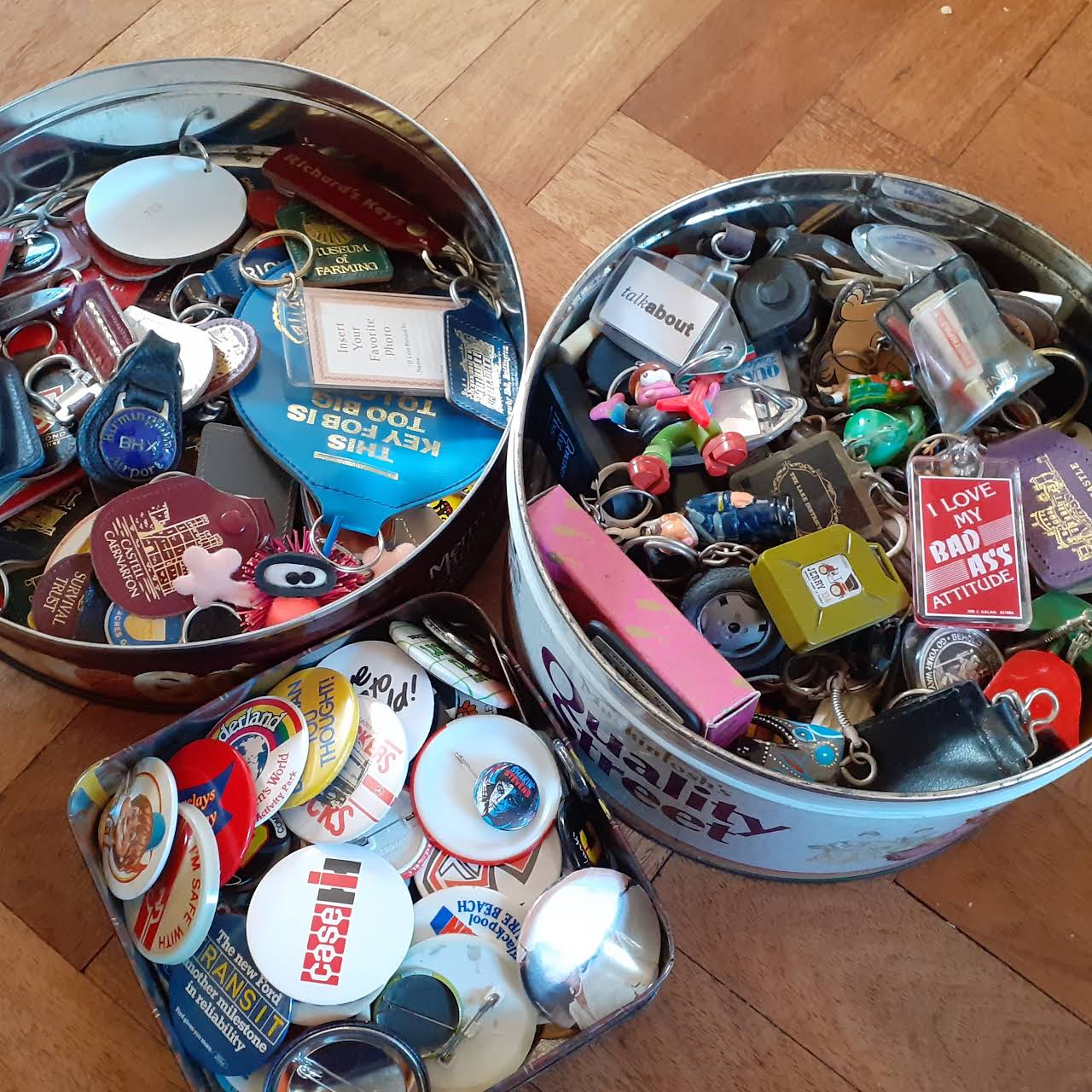 Round tins full of key-rings and badges for sale at The Indie Arcade.