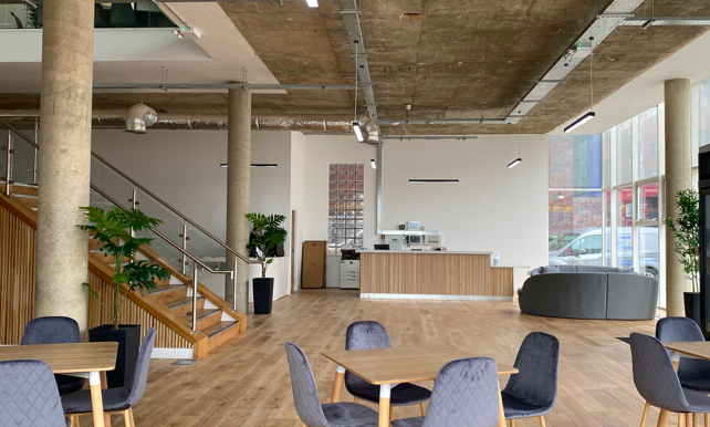 Inside Cubo, an open plan workspace with tables and chairs.