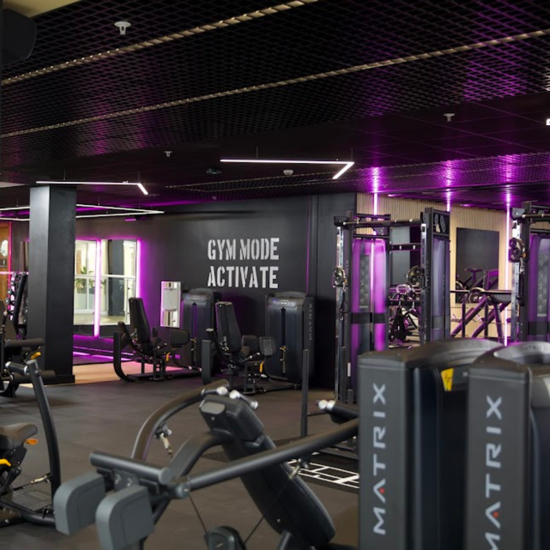 Gym equipment illuminated by purple lighting.
