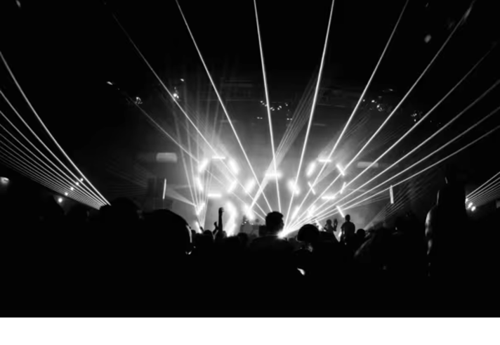 A black and white photograph of a crowd dancing in a nightclub.