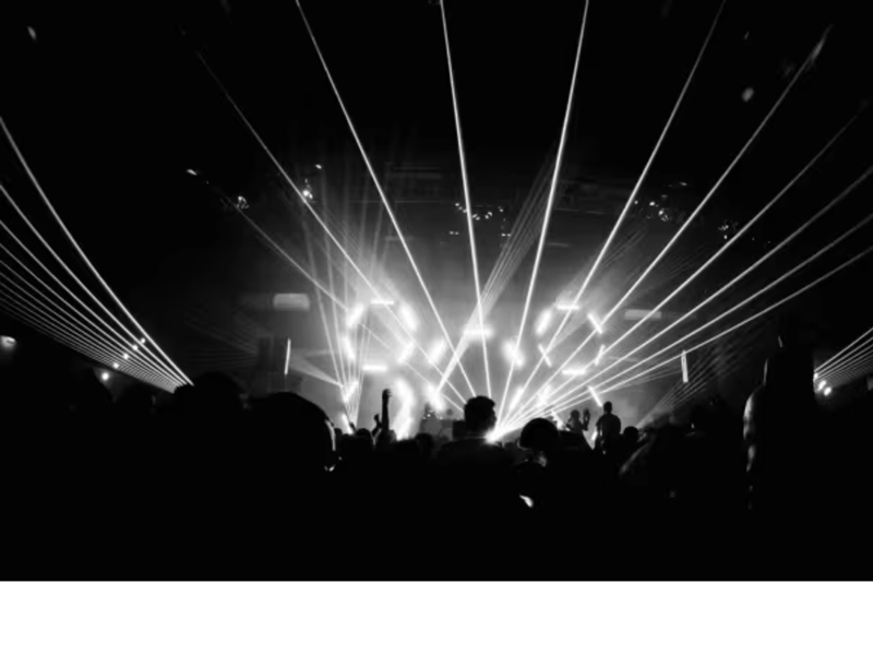 A black and white photograph of a crowd dancing in a nightclub.