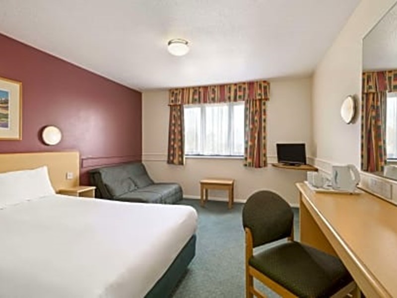 Bedroom featuring a double bed positioned near a window with natural light.