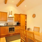 Bright country kitchen with wooden cabinets, countertops, and dining area.