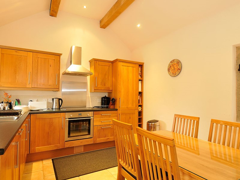 Bright country kitchen with wooden cabinets, countertops, and dining area.