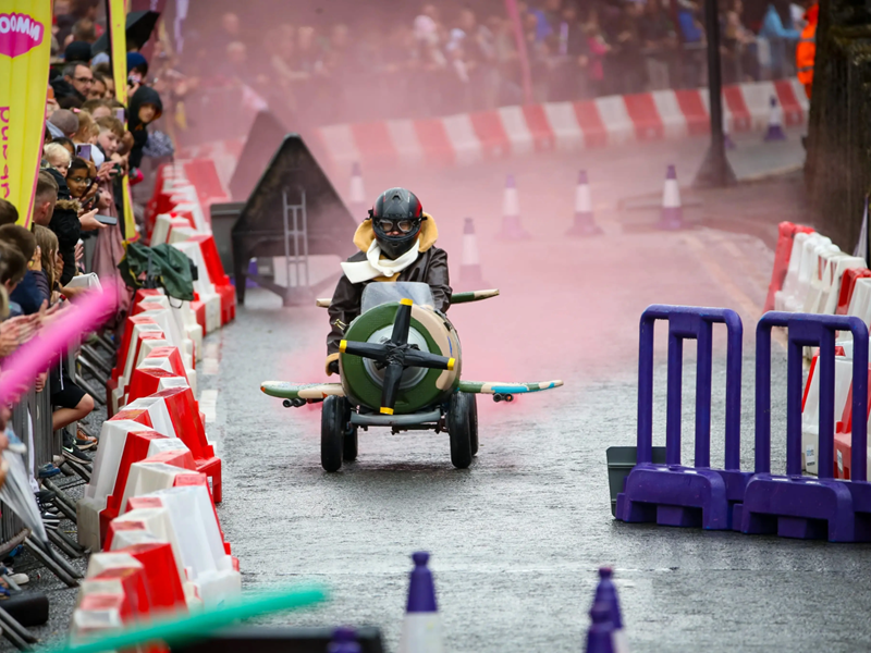 A kart (styled as a WWII fighter plane) races down the track.