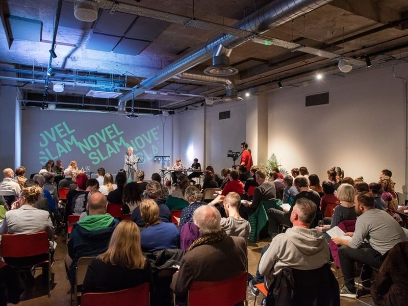 A seated audience listening to a speaker at an Off The Shelf event.