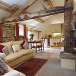 The living room in a small boutique hotel, with beams on the ceilings and stone walls.