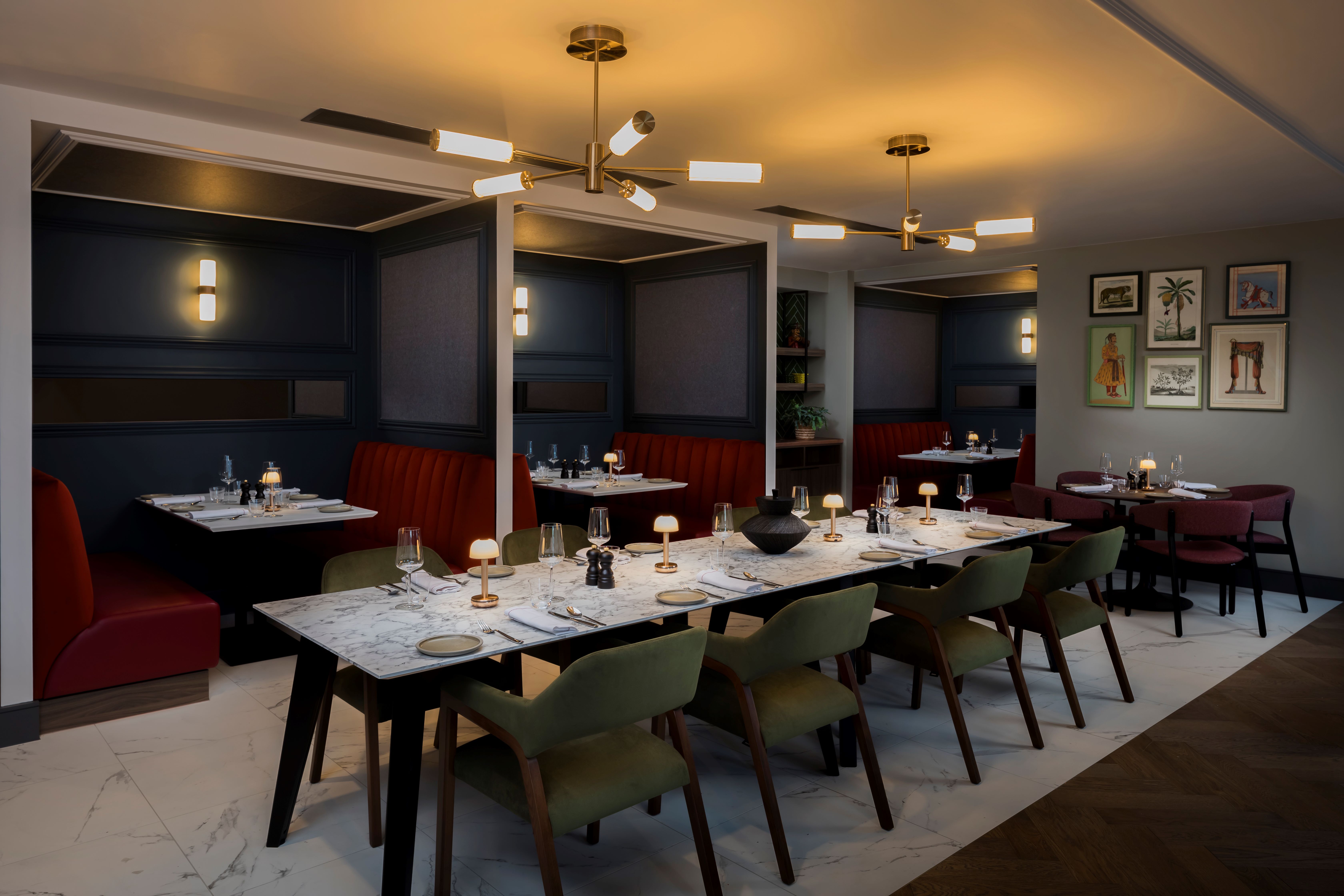 Restaurant with a set long table and chairs, with booths positioned behind.