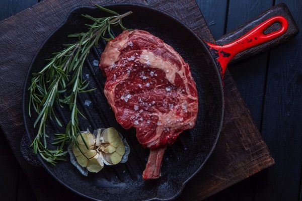 A steak in an iron griddle.