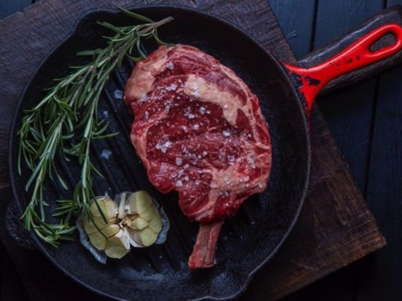 A steak in an iron griddle.