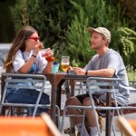 Two people having a drink in the outdoor seating area at Forum Kitchen + Bar.