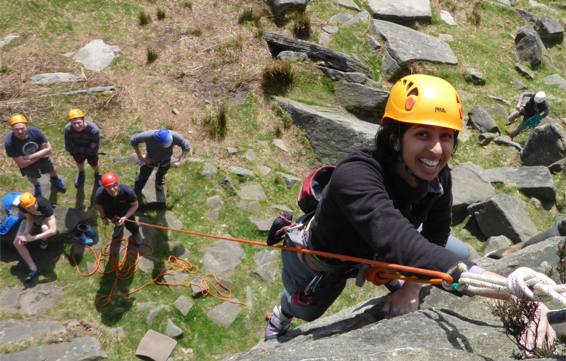 People learning to climb a rock face.