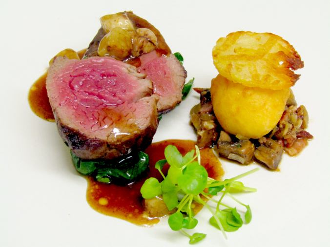 A plate of roast beef with Yorkshire pudding and vegetables.