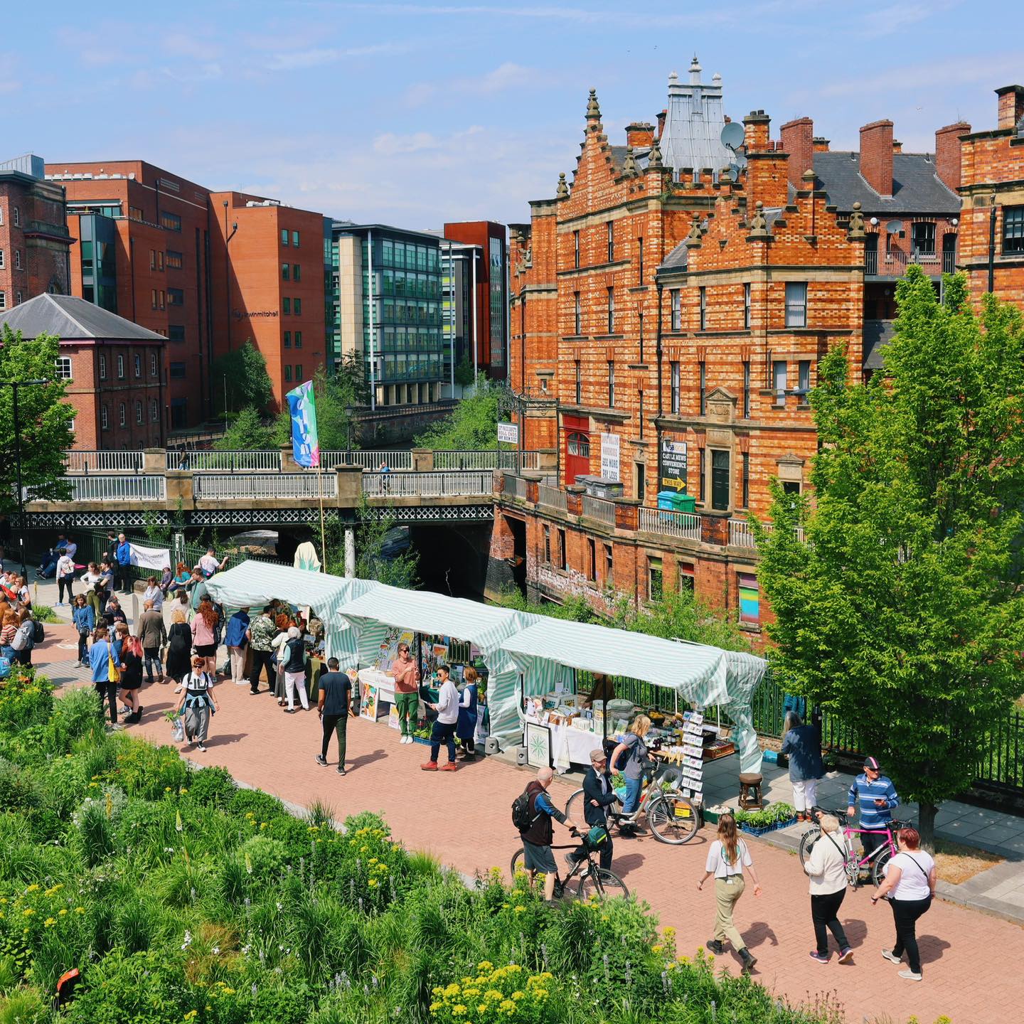 Crowds of people are walking around and shopping at Pollen Market, an outdoor flower market that is held once a month.