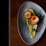 A plate with a scotch egg cut in two.