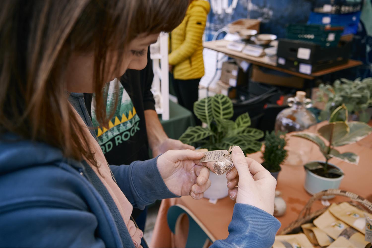 Girl looking at tag of item on plant stall