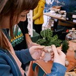 Girl looking at tag of item on plant stall