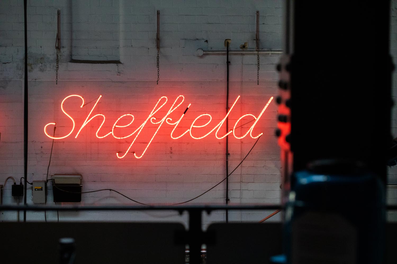 A red neon sign in a window that reads 'Sheffield'.