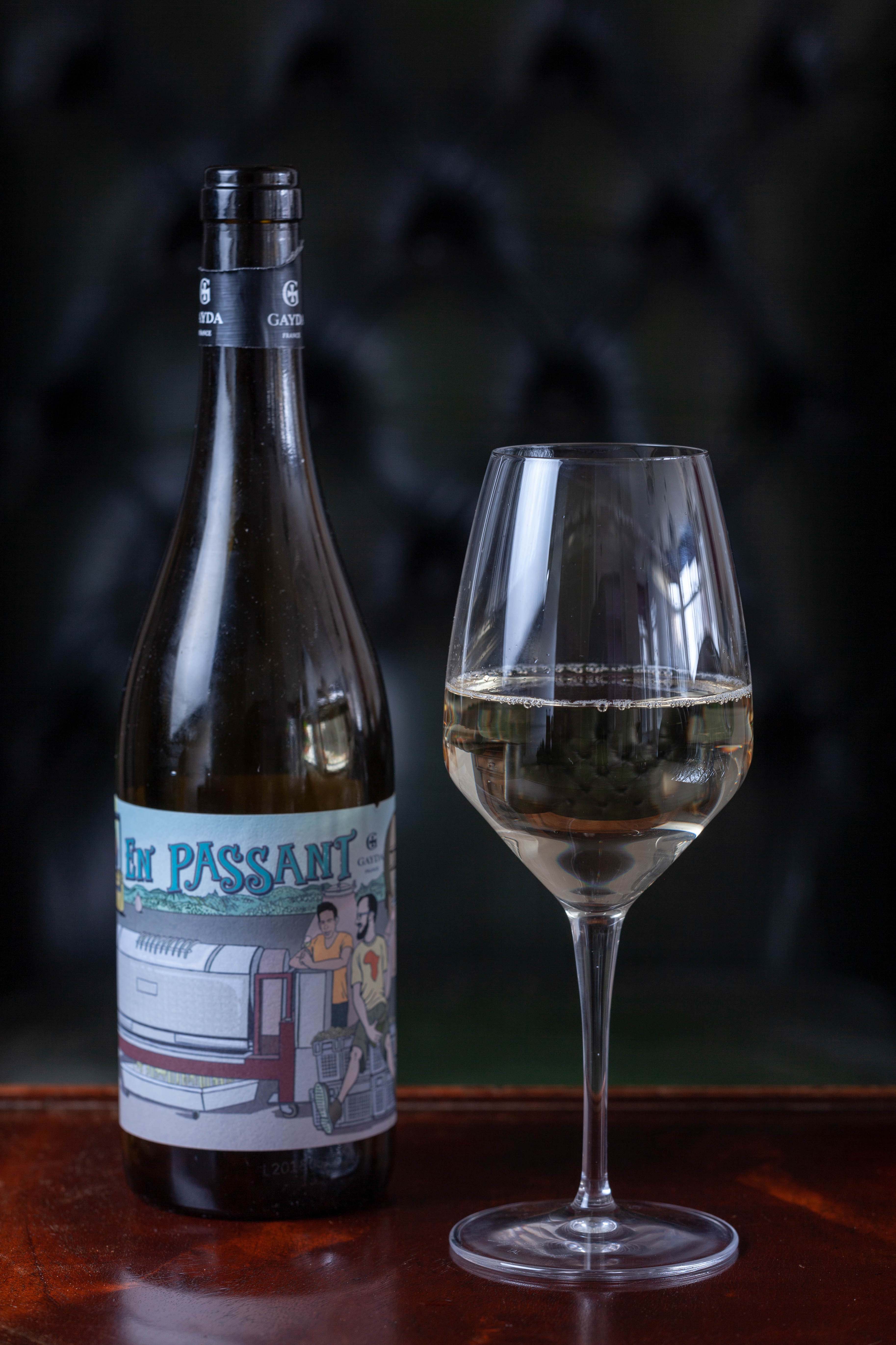 A glass of wine stood next to a bottle on a table.