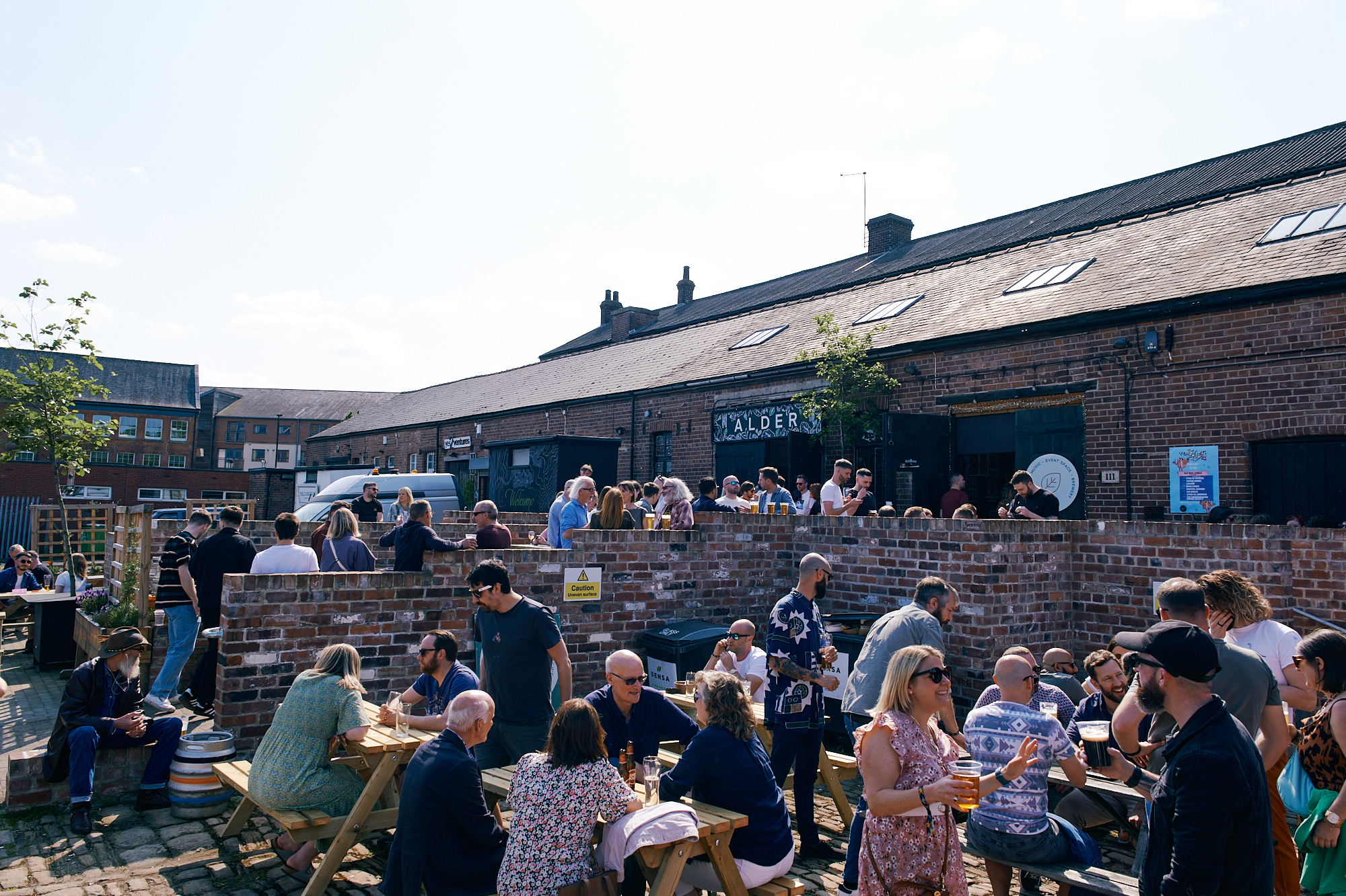 Courtyard full of people socialising in sunshine at Alder Bar in Kelham Island 