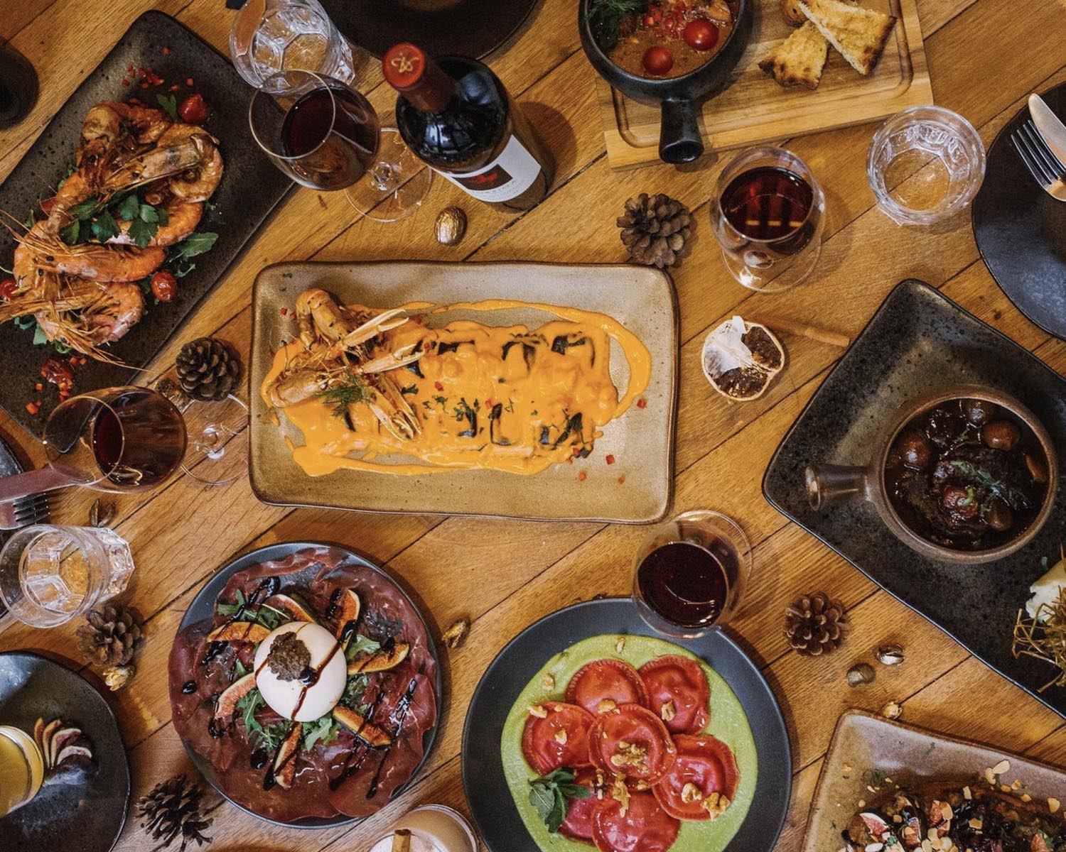 An overhead shot of a table filled with various different plates of food.