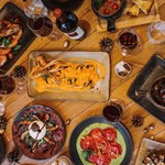An overhead shot of a table filled with various different plates of food.
