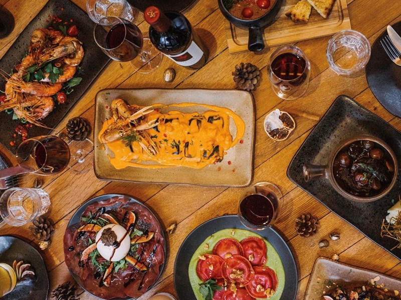 An overhead shot of a table filled with various different plates of food.
