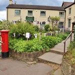 Wortley Cottage Guest House with stone walls, pitched roof, and garden area in front.