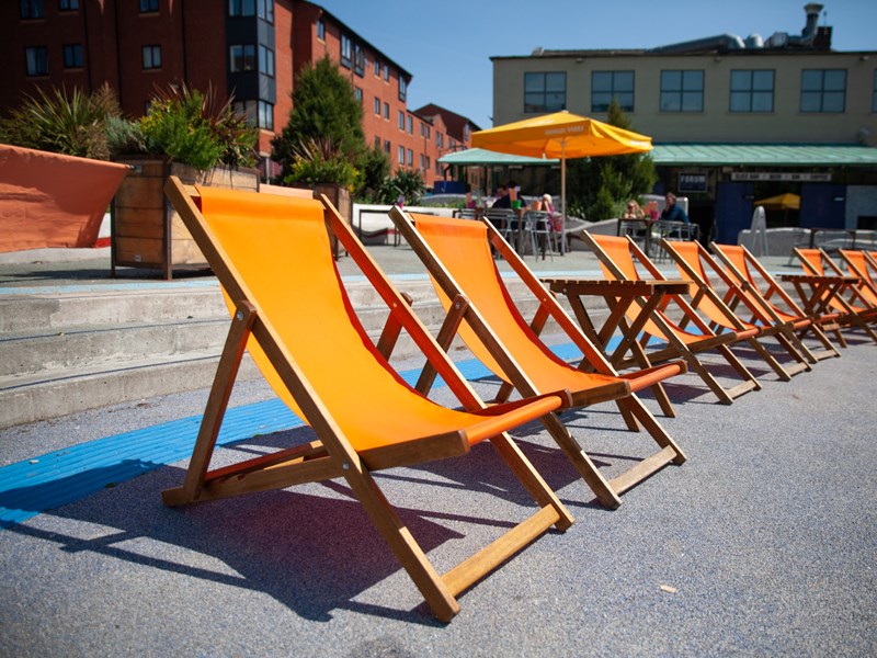 A row of orange deckchairs in the outside seating area at the Forum Kitchen + Bar.