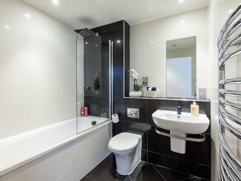 Modern black and white bathroom with sleek fixtures and contrasting tile design.
