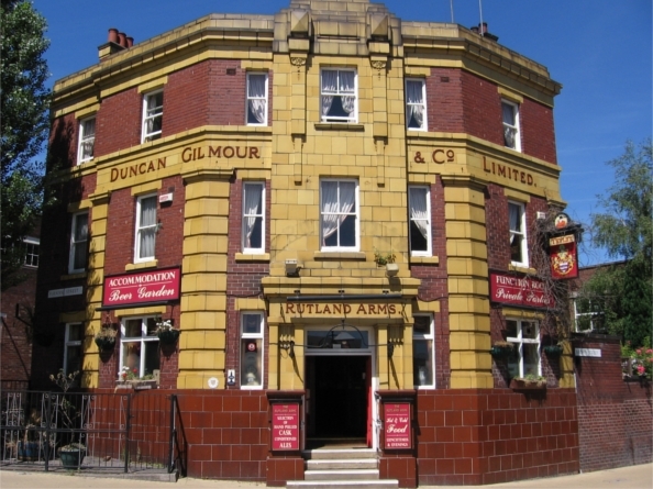 An exterior shot of the Rutland Arms, a pub built in yellow stone and red brick.