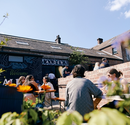 People enjoying the sunny exterior of Alder Sheffield in Kelham Island